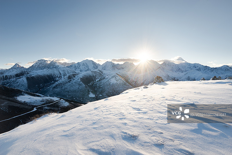 日出时分的贡戛山脉与雪地图片素材
