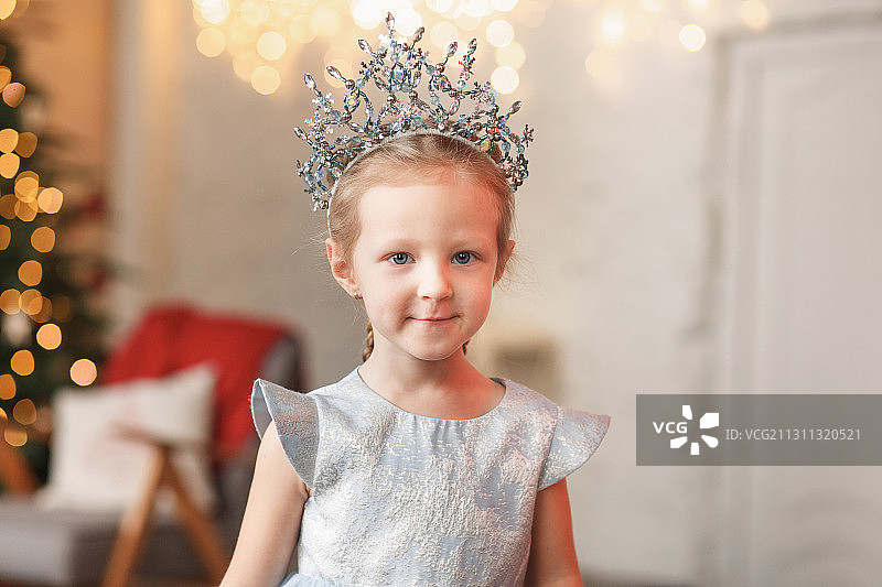 小女孩在家中圣诞树旁扮公主图片素材