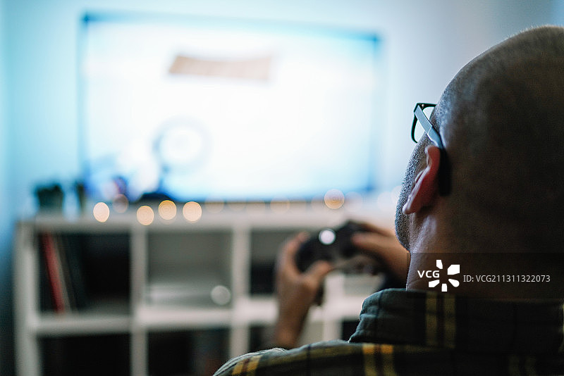 白人男子在西班牙莱里达舒适的沙发上玩电子游戏图片素材