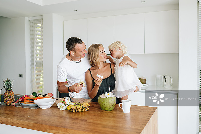 幸福的白人家庭在泰国帕岸岛度假时，在厨房一起享用健康水果早餐图片素材