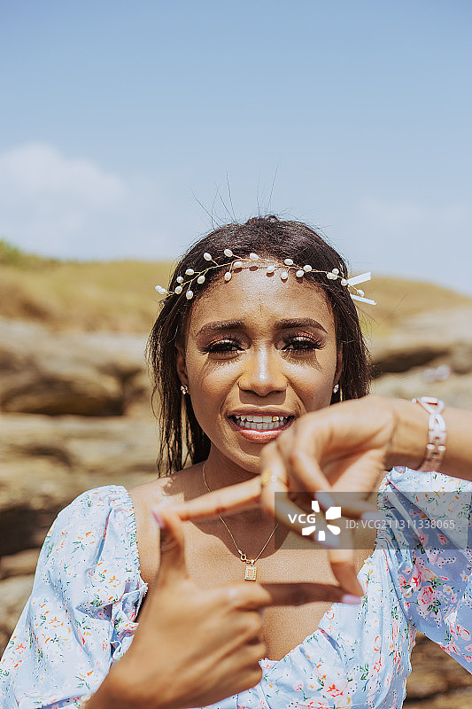 在加纳阿克拉海滩身穿连衣裙和花冠的圭亚那年轻女子图片素材