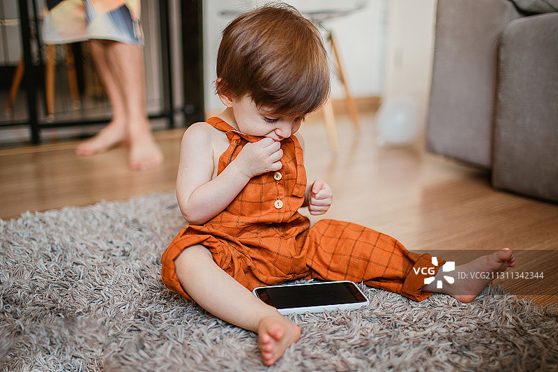 小男孩在家玩智能手机，巴西米纳斯吉拉斯州贝洛奥里藏特图片素材