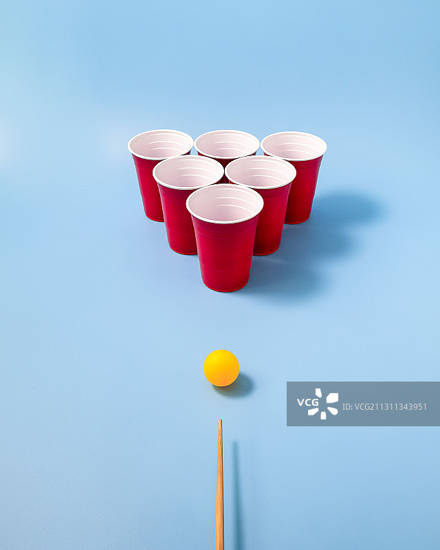 新加坡蓝色背景下的饮料杯和撞球杆（高角度拍摄）图片素材