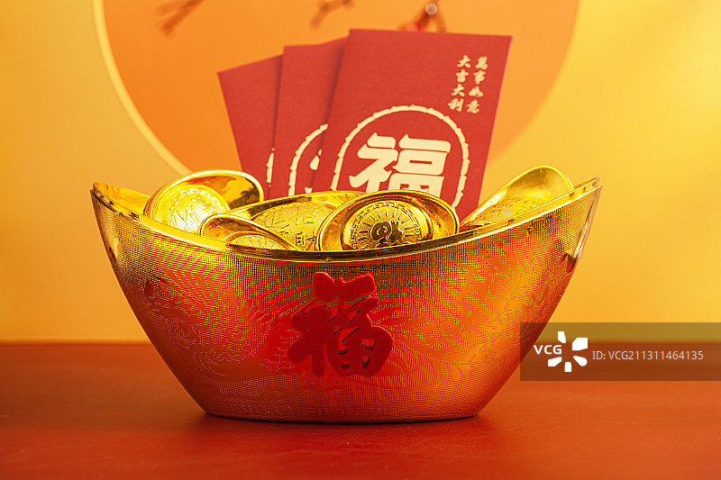 摆放在聚宝盆里面的金元宝和新年红包图片素材