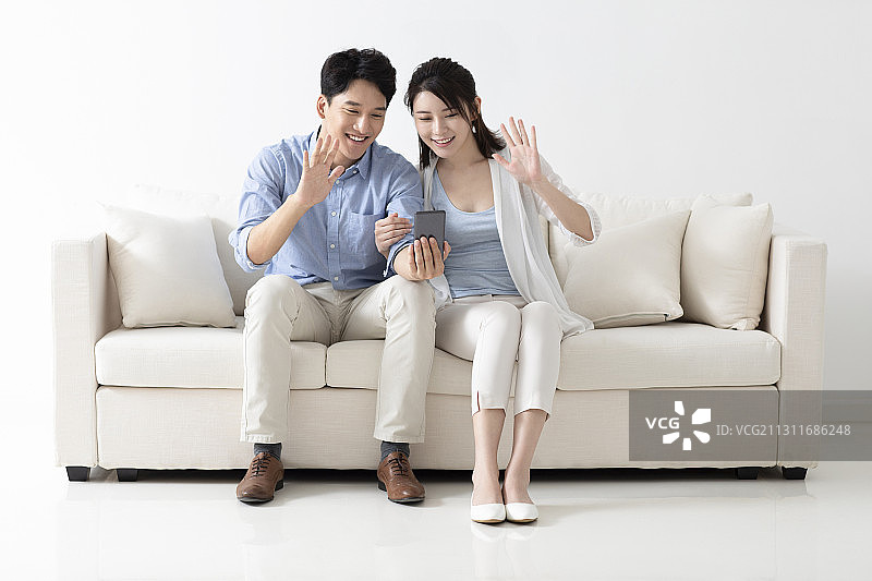 开心的年轻情侣玩手机图片素材