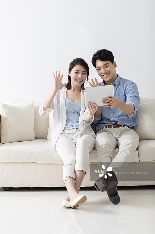 开心的年轻情侣玩平板电脑图片素材