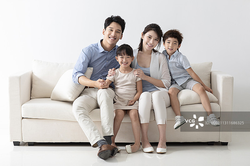 开心的一家四口坐在沙发上图片素材