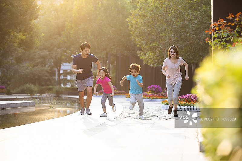 开心的一家人在公园赛跑图片素材