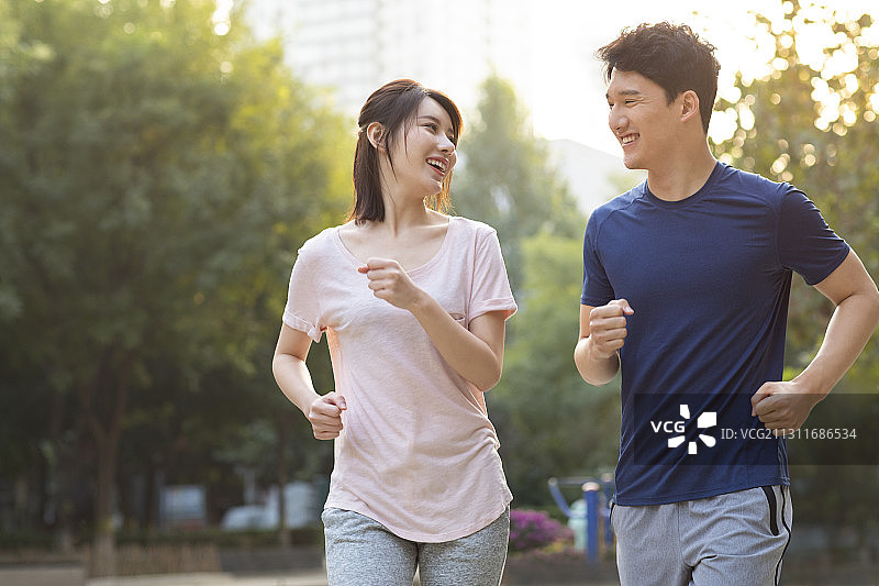 开心的年轻情侣在公园跑步健身图片素材