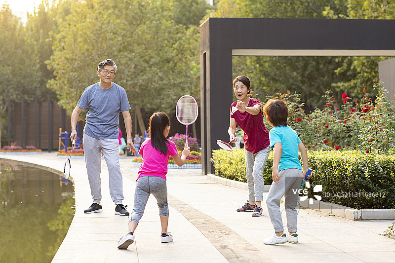 开心的一家人在公园打羽毛球图片素材