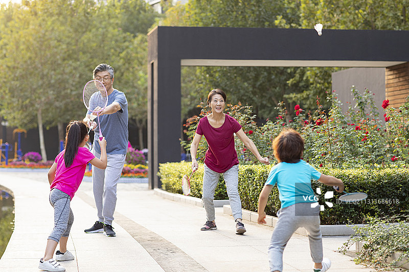 开心的一家人在公园打羽毛球图片素材