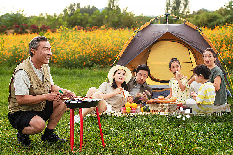 快乐家庭在郊外烧烤野餐图片素材