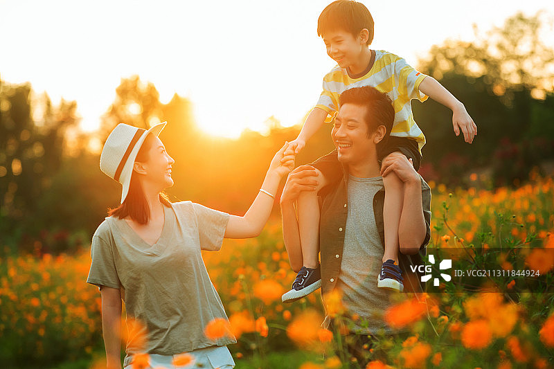 幸福的一家三口站在花丛中图片素材