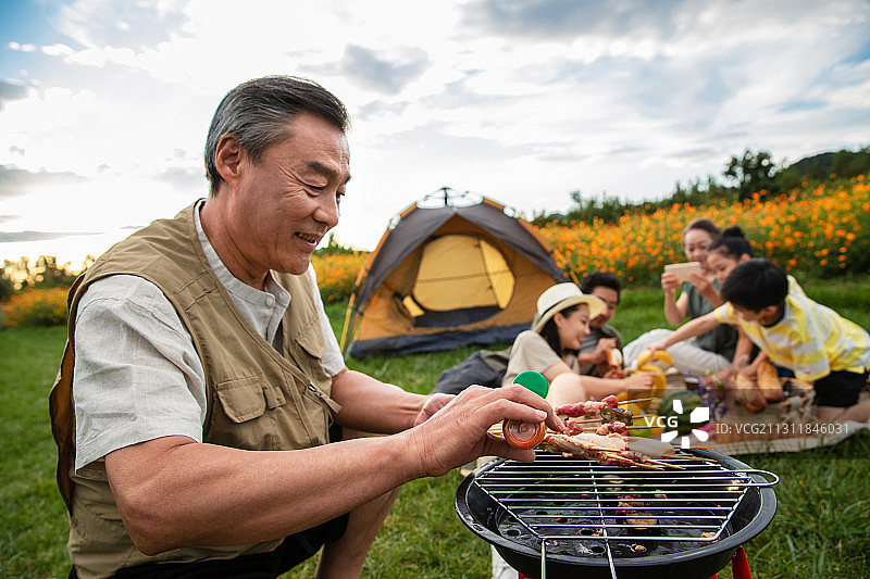 快乐家庭在郊外烧烤野餐图片素材