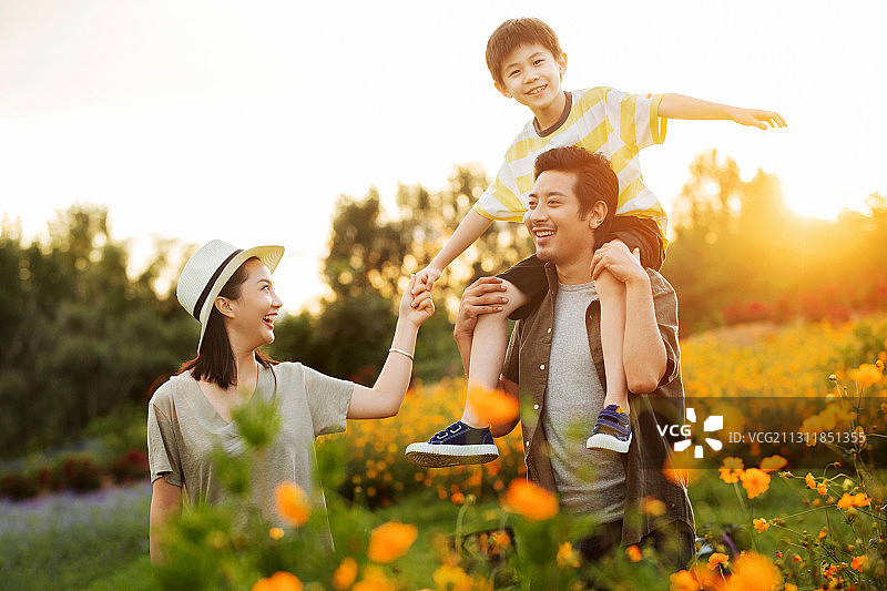 幸福的一家三口站在花丛中图片素材