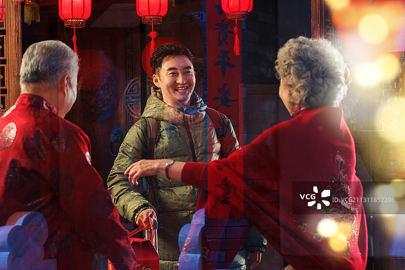 青年男人过年回家和父母团圆图片素材