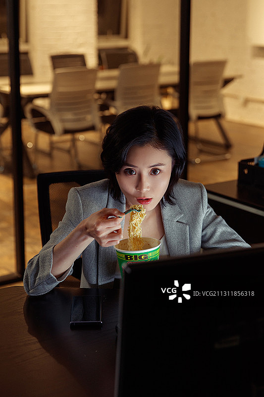 在办公室加班的青年女人图片素材