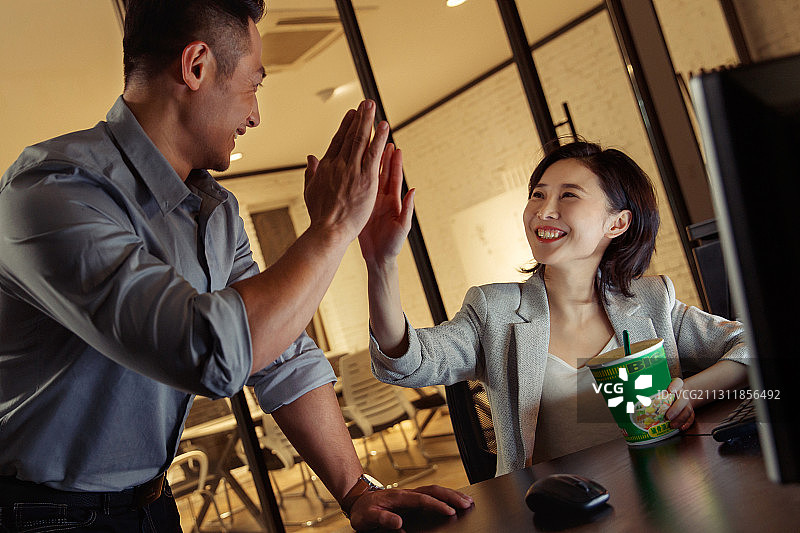 商务人士在办公室击掌庆祝图片素材