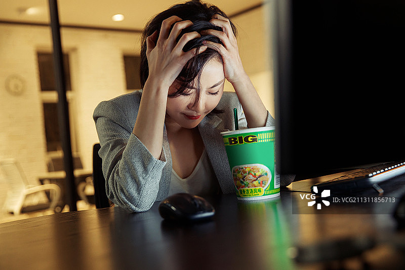 在办公室加班的青年女人图片素材