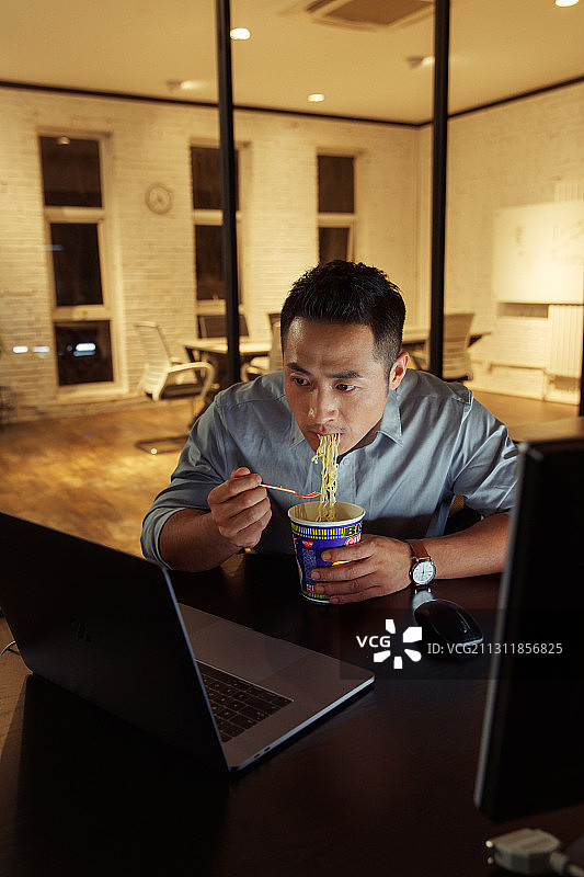 在办公室加班吃方便面的青年男人图片素材