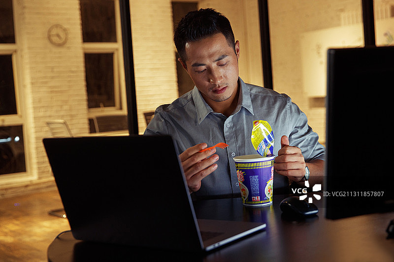 在办公室加班吃方便面的青年男人图片素材