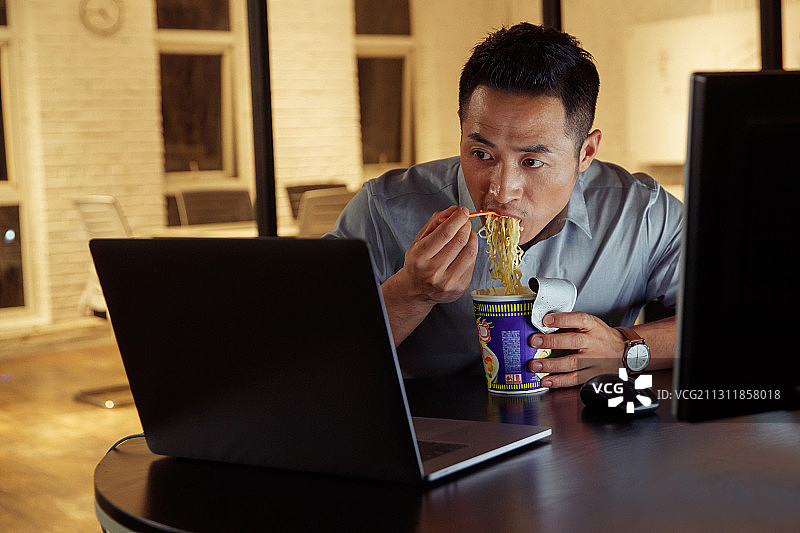 在办公室加班吃方便面的青年男人图片素材