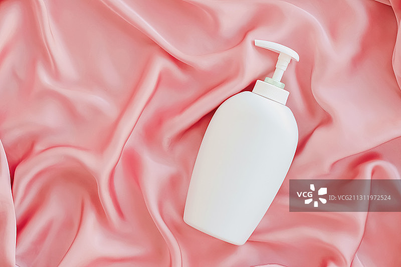 粉色丝绸上的化妆品容器产品模型图片素材