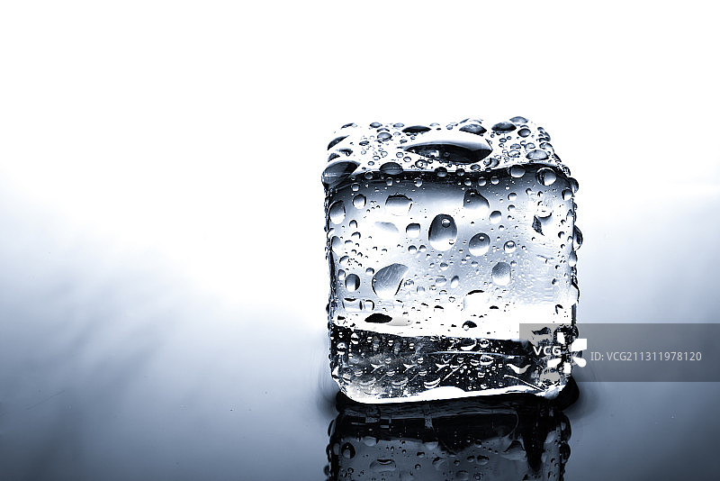 白色背景下的玻璃杯中冰块特写图片素材