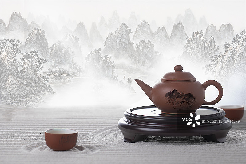 山水画前的中国茶壶和茶杯在枯山水上富有禅意的意境图片素材