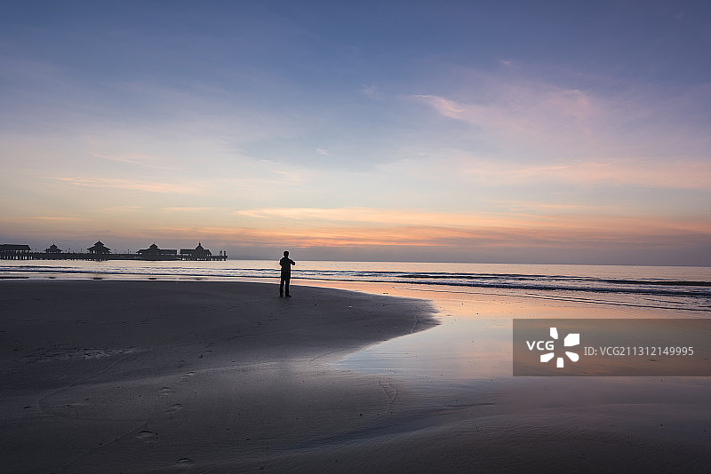 黎明一个站在海南文昌高隆湾海滩上看日出的人图片素材