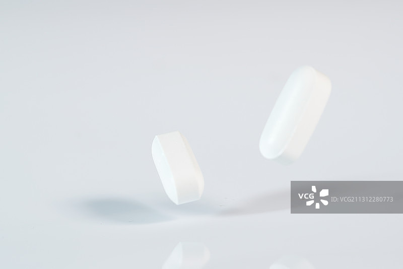 高速跳动的药丸钙片白色背景棚拍广告素材图片素材