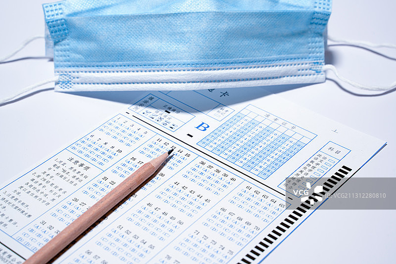 一只口罩旁边的答题卡和一支铅笔图片素材
