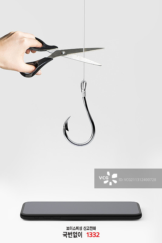 语音钓鱼主题编辑图像，人手在智能手机上方切割鱼钩图片素材