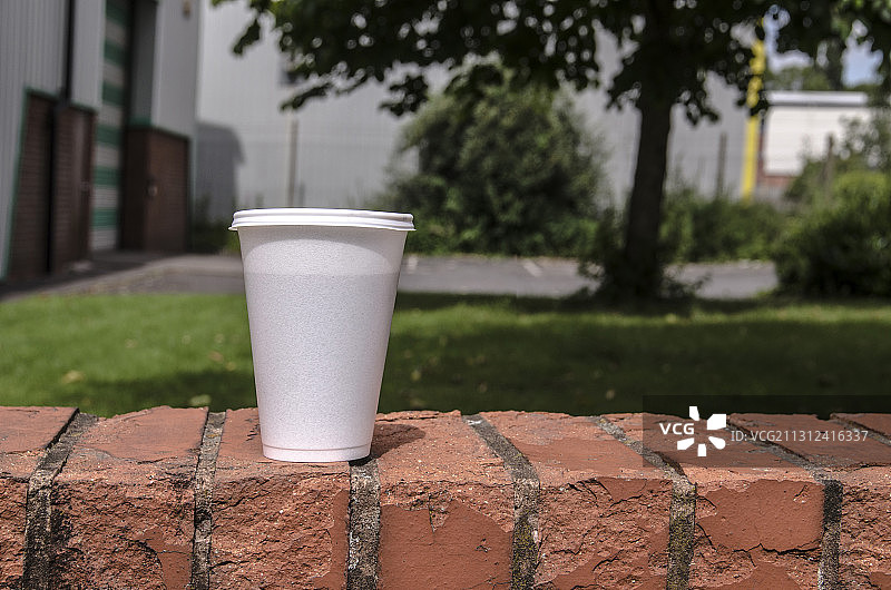 商业园区墙上的塑料杯外卖咖啡图片素材