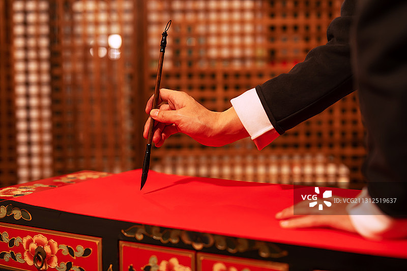 一个东方男子手拿毛笔写春联图片素材