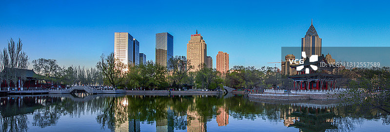 新疆乌鲁木齐人民公园市中心cbd地标建筑日落图片素材