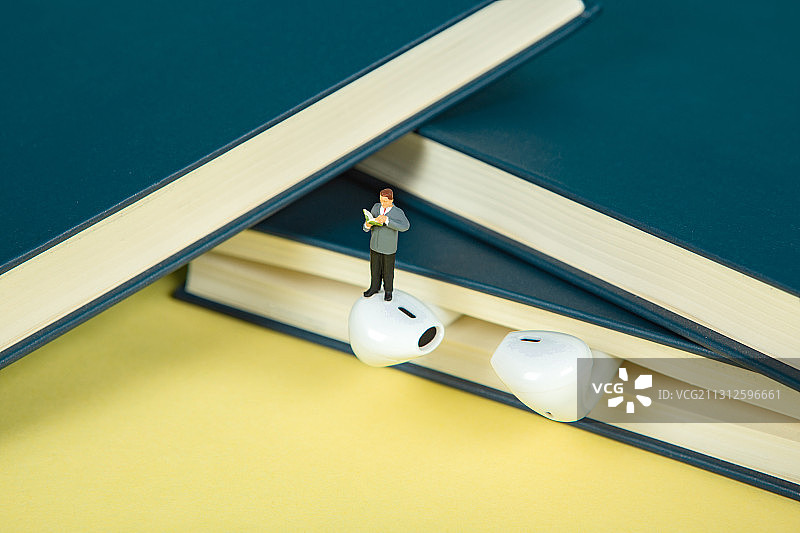 在书本里带耳机阅读学习的人有声小说有声读物在线听书学习图片素材