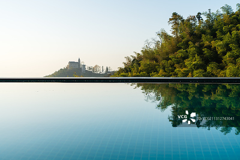 浙江省湖州市德清莫干山游泳池平静水面倒影天鹅堡留白图片素材