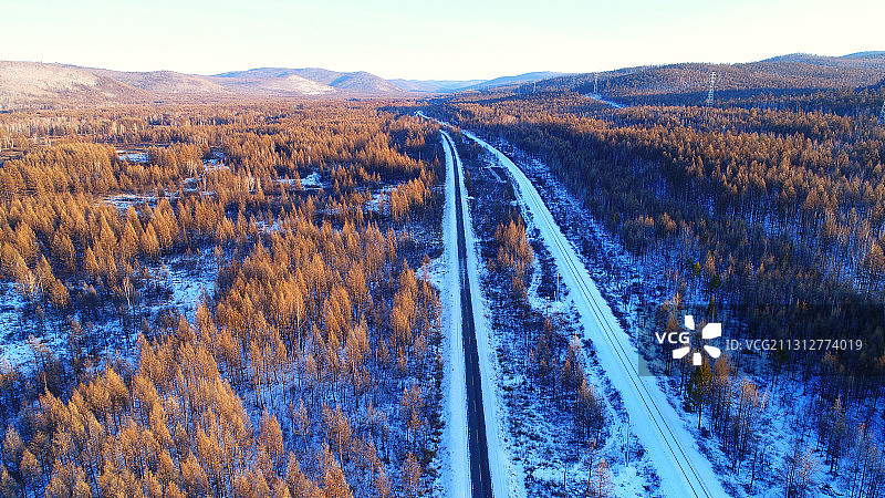 航拍大兴安岭穿越冰雪森林的铁路、公路图片素材