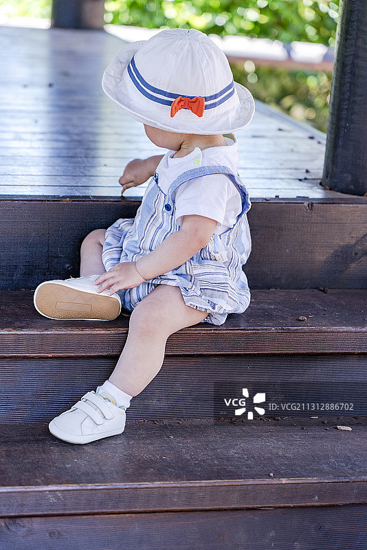 戴遮阳帽婴儿坐在木台阶图片素材