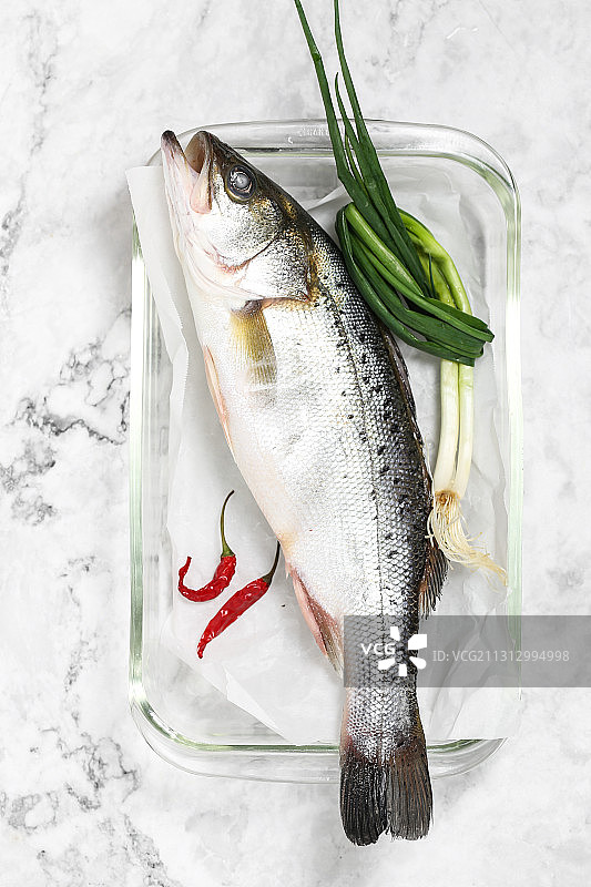 放在透明玻璃盘子里的冰鲜海鲈鱼图片素材