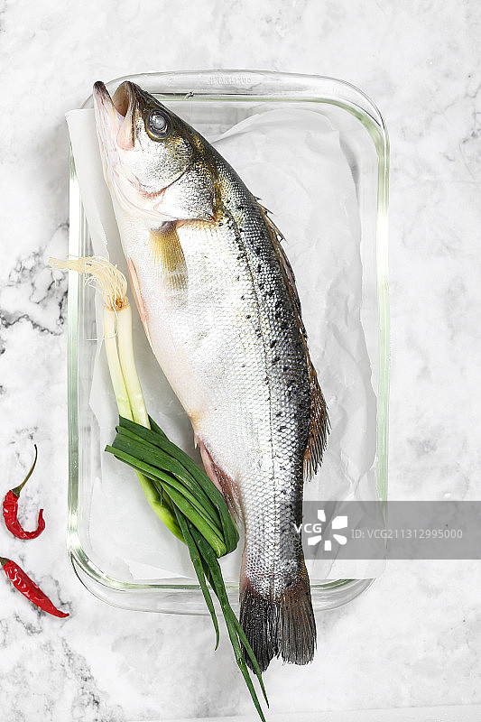 放在透明玻璃盘子里的冰鲜海鲈鱼图片素材