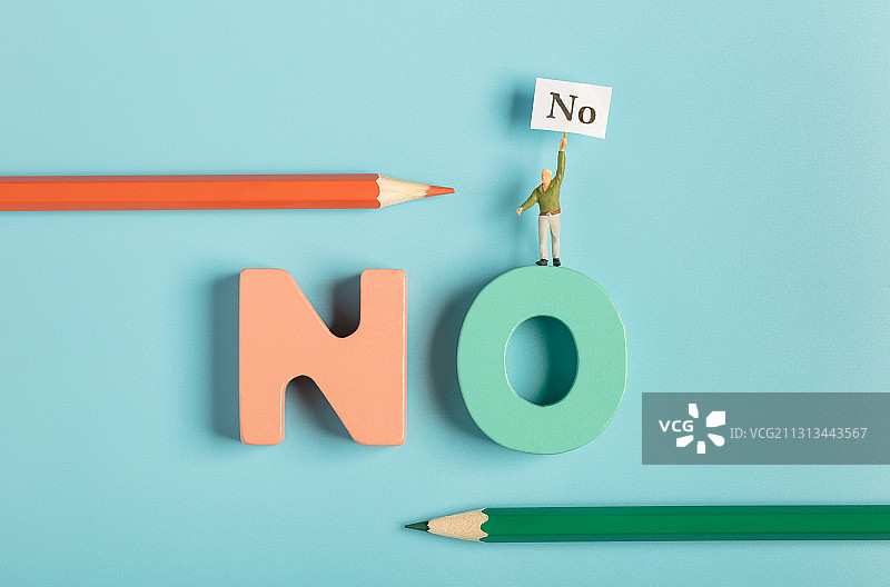 举着牌子站在积木英文字母NO上的人图片素材