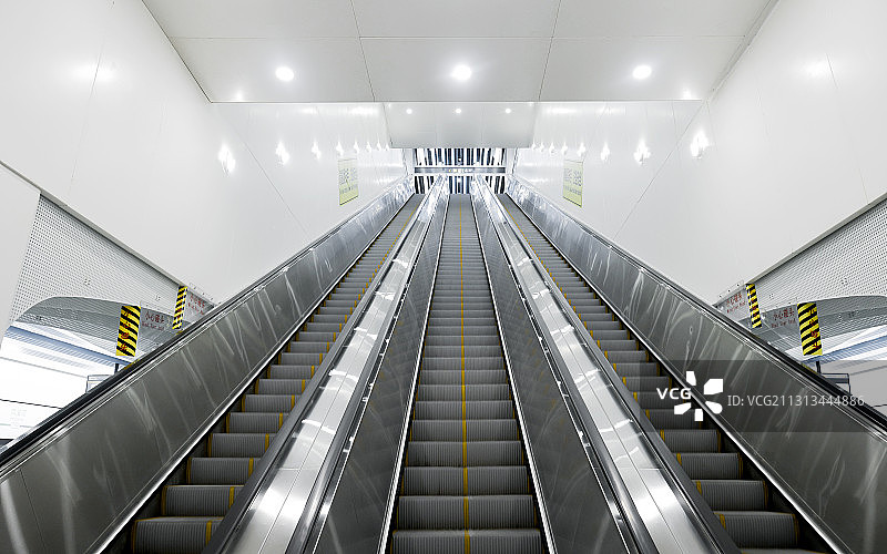 地铁站里三个向上运行的电动扶梯图片素材