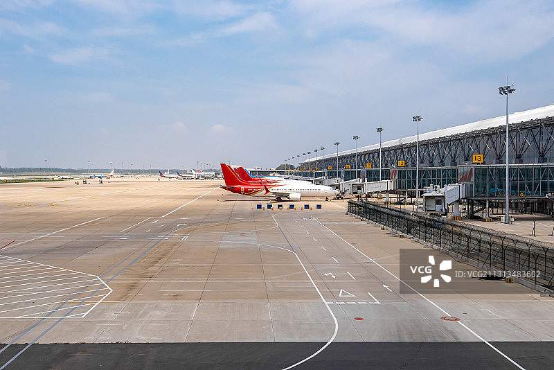 大型国际机场航站楼外停机坪廊桥旁停放的飞机景观图片素材