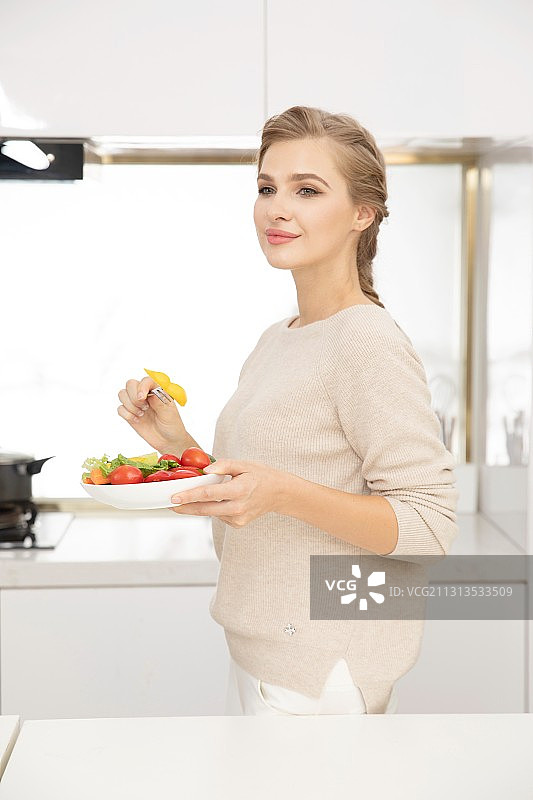 站在厨房前的年轻西方女性图片素材