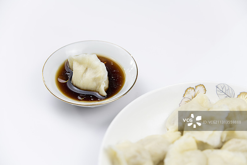 白色背景中放在醋中的饺子图片素材