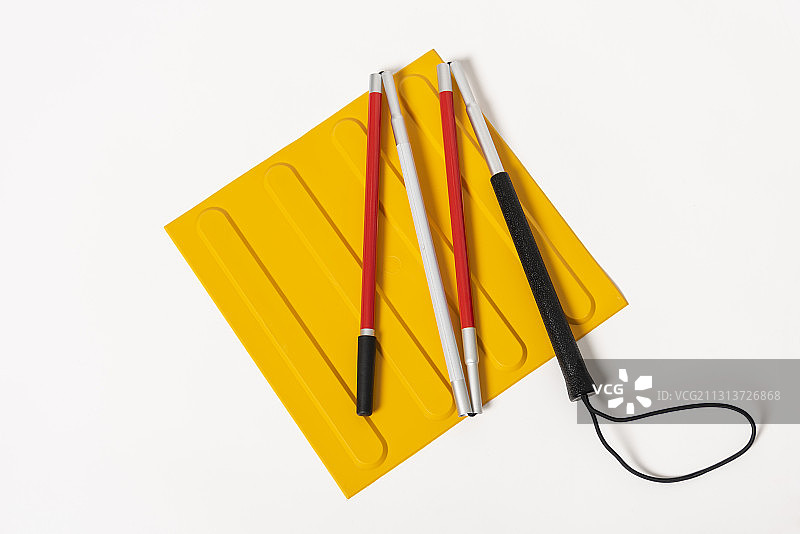 白色背景黄色垫子上的折叠手杖图片素材