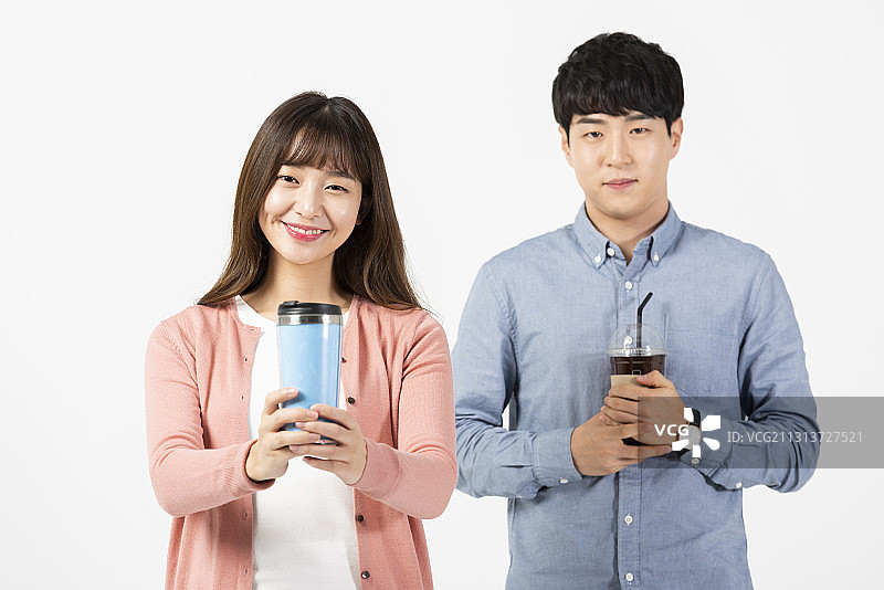 两位大学生拿着水杯和塑料咖啡杯，白色背景图片素材