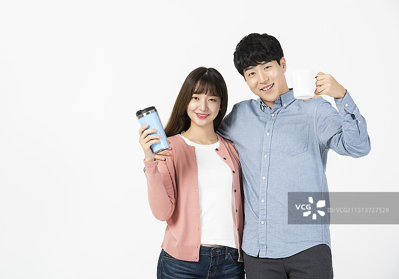 两位大学生手持杯子在白色背景下微笑图片素材